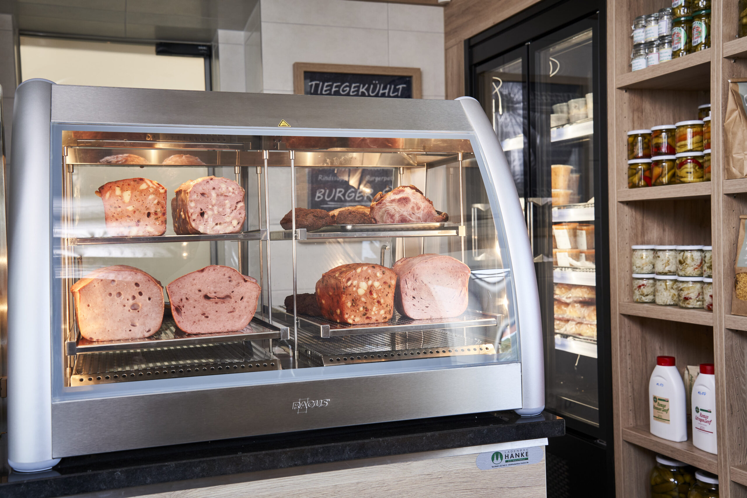 Heißbegehrt: In der neuen Heißen Theke warten klassische Fleischerschmankerln – vom Leberkäse bis zum Braten – appetitlich präsentiert und stets frisch zubereitet auf hungrige Kunden.