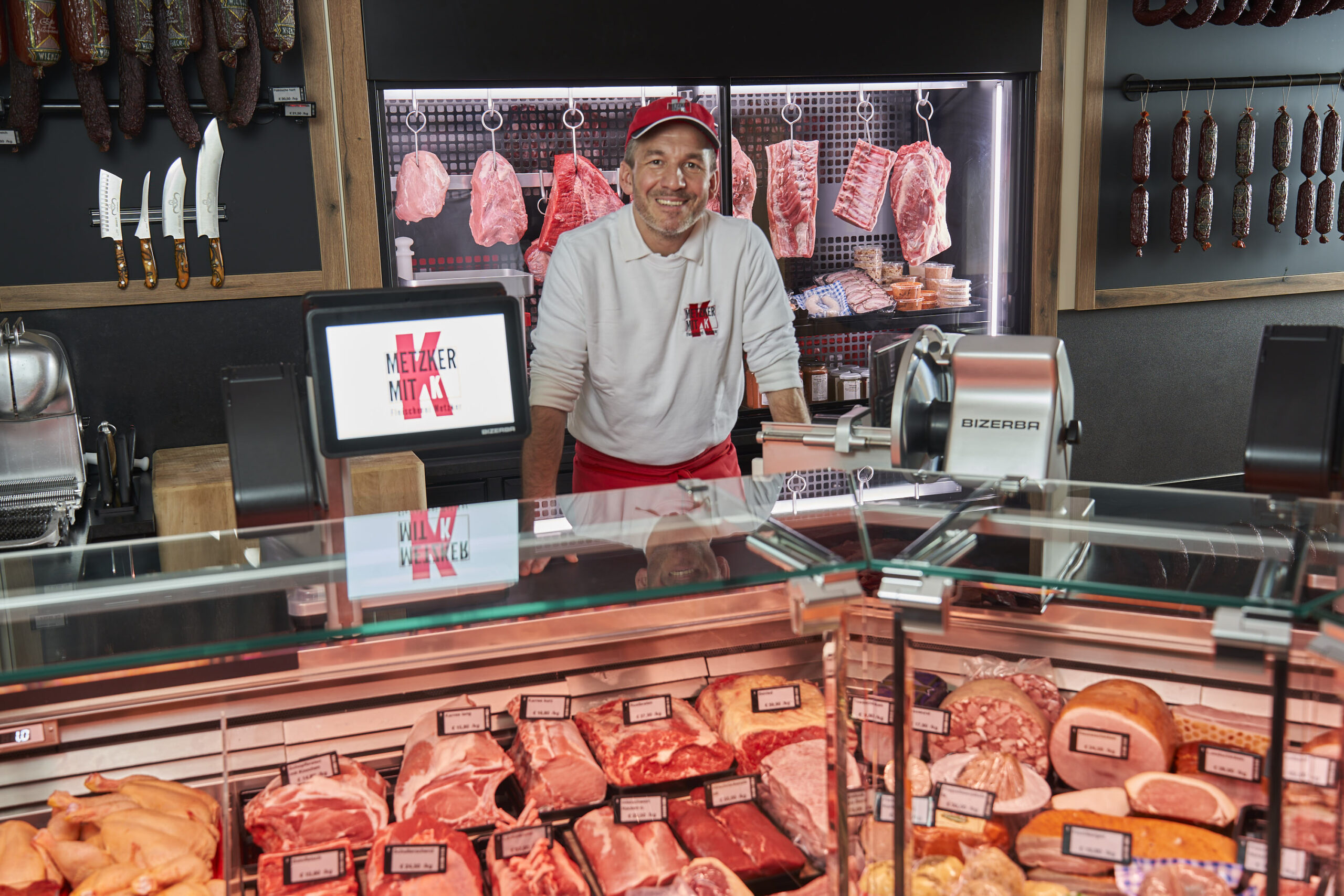 Fleischermeister Christian Metzker steht stolz hinter seiner neuen Verkaufstheke. Der Umbau durch Hanke Ladenbau verbindet Funktionalität, klares Design und handwerkliche Atmosphäre.