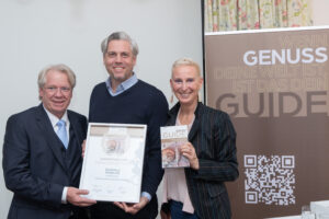 Den Sonderpreis Familienbetrieb 2026 erhielt die Ölmühle Fandler. Im Bild v.l.n.r.: Willy Lehmann (Herausgeber Genuss), Hans Jörg Stinauer (Ölmühle Fandler), Andrea Knura (Autorin und Herausgeberin Genuss Guide) © Tanzer